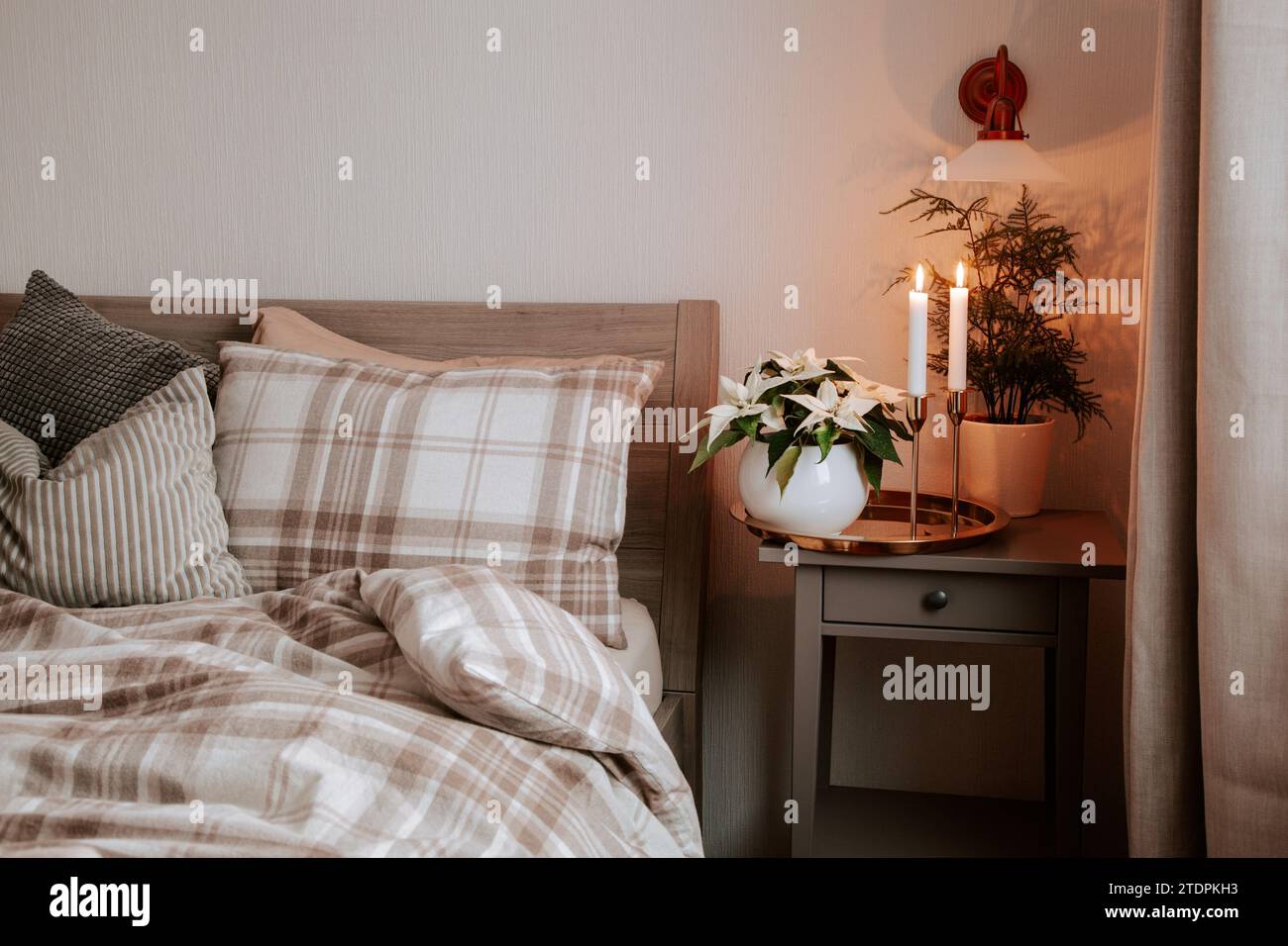 cozy scandinavian bedroom interior in natural tones, blanket candles houseplants Stock Photo