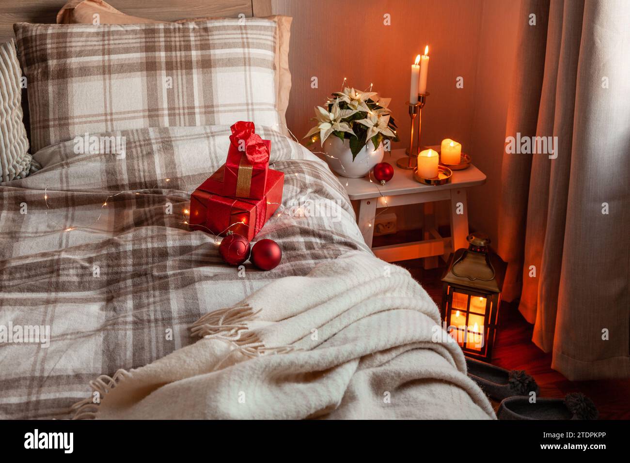 cozy scandinavian bedroom interior in natural tones, blanket candles christmas gift box Stock Photo