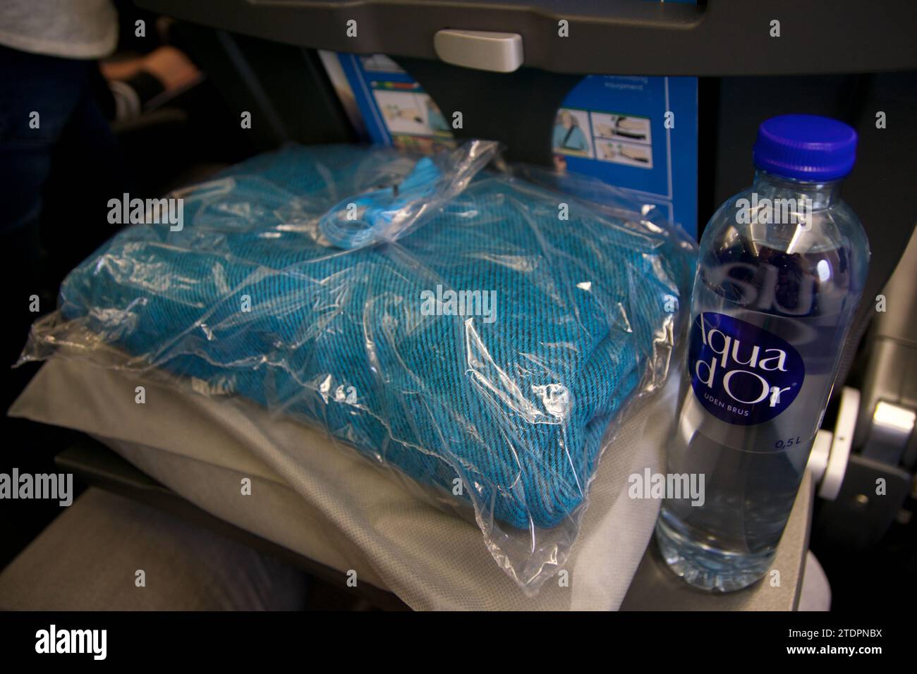 KOPENHAGEN, DENMARK - NOV 24, 2018: Amenities such as a blanket, pillow and a bottle of water in Economy Class on a long-haul flight to San Francisco Stock Photo