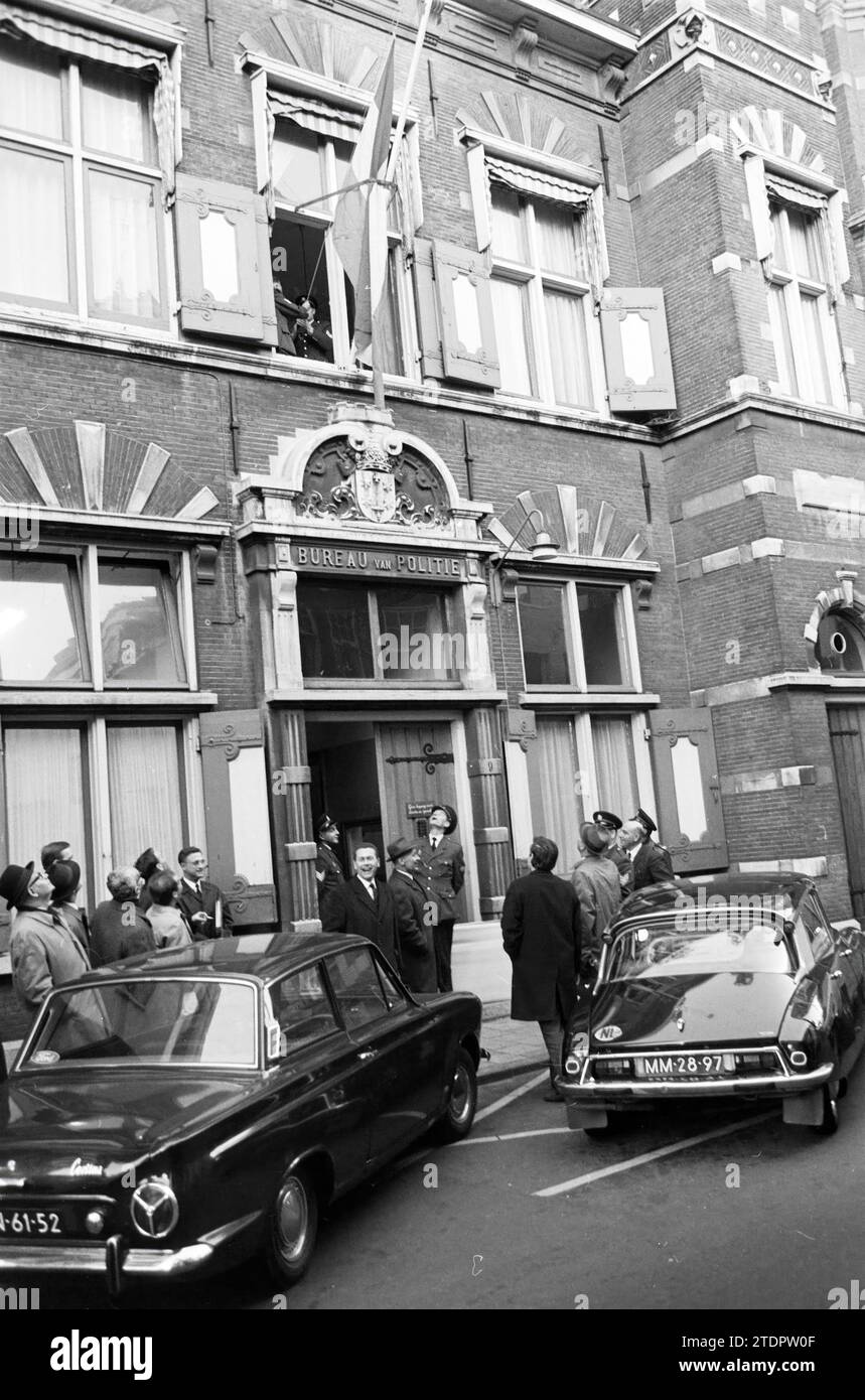 Meeting with displaying a flag at the police station in Smedestraat, small gathering of officers, guests and passers-by., Haarlem, Smedestraat, The Netherlands, Whizgle News from the Past, Tailored for the Future. Explore historical narratives, Dutch The Netherlands agency image with a modern perspective, bridging the gap between yesterday's events and tomorrow's insights. A timeless journey shaping the stories that shape our future Stock Photo