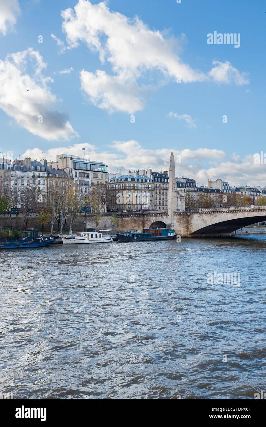 Paris, France, 2023. The Pont de la Tournelle and the statue of Saint Genevieve, with the Tour d'Argent restaurant in the background (vertical) Stock Photo