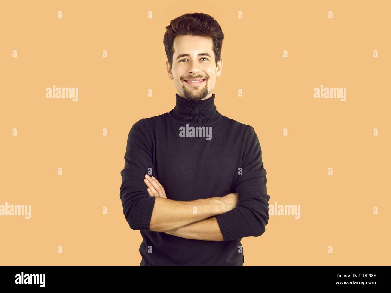 Portrait of confident young man crossing hands smiling at camera Stock Photo