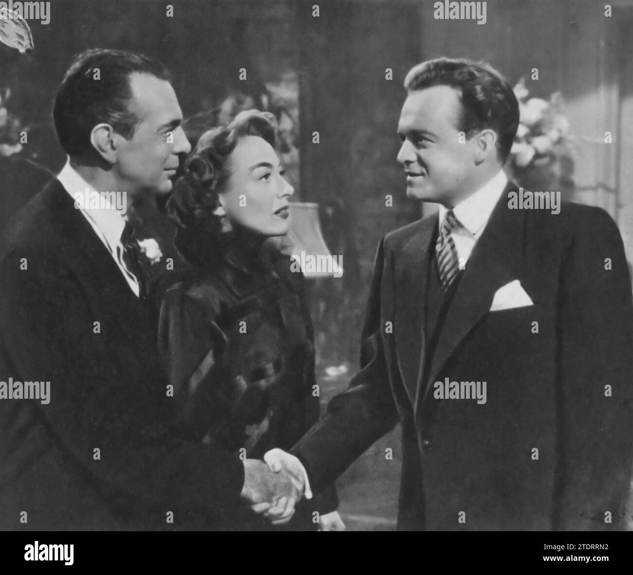 Joan Crawford, Van Heflin, and Raymond Massey star in 'Possessed' (1947). Crawford delivers an intense performance as a mentally unstable woman obsessed with Heflin's character, while Massey plays the supportive yet oblivious husband. Their interplay creates a tense and gripping narrative, showcasing Crawford's depth as an actress, a role that earned her an Academy Award nomination. Stock Photo