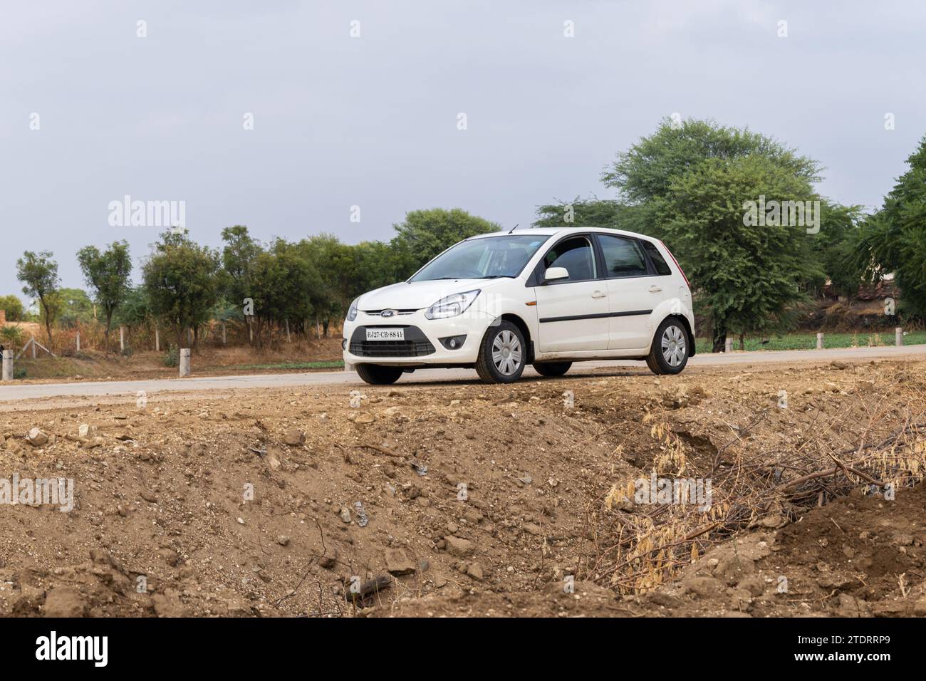 isolated white car at remote highway at evening from flat angle Stock Photo