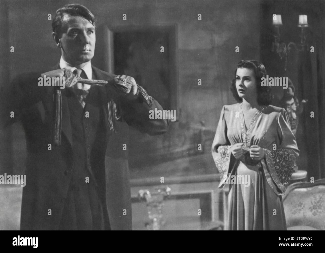 Michael Redgrave and Joan Bennett star in the psychological thriller 'Secret Beyond the Door' (1947). Directed by Fritz Lang, this film delves into the darker aspects of the human psyche. Redgrave plays a man with a mysterious past, and Bennett portrays his new wife who becomes increasingly concerned about her husband's strange behavior and the secrets hidden in their home. The film is known for its suspenseful atmosphere and exploration of themes such as obsession and paranoia, with Redgrave and Bennett delivering intense and captivating performances. Stock Photo