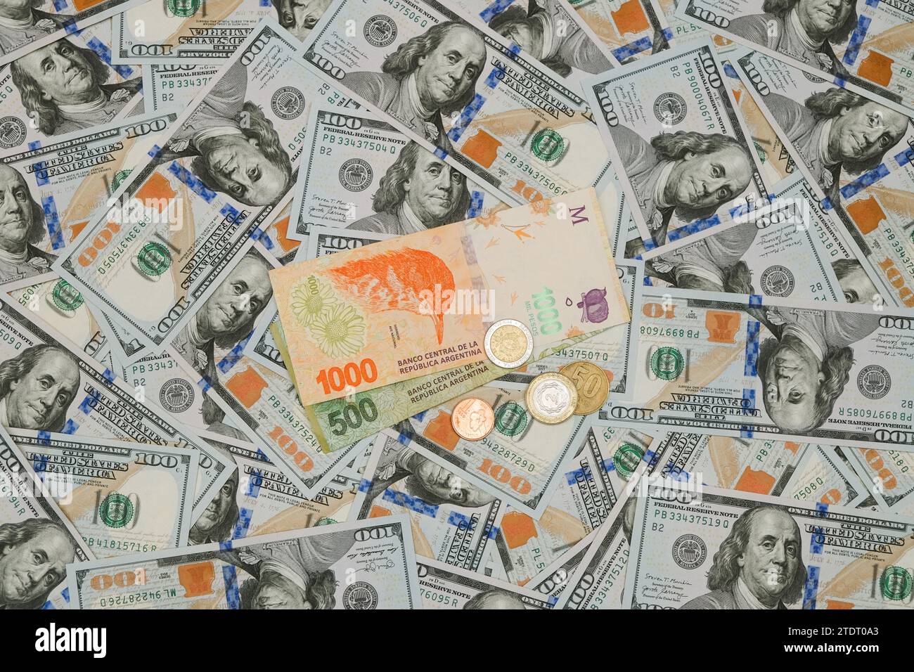 Argentine Pesos On A Background Of US Dollars. Financial Crisis Concept Stock Photo