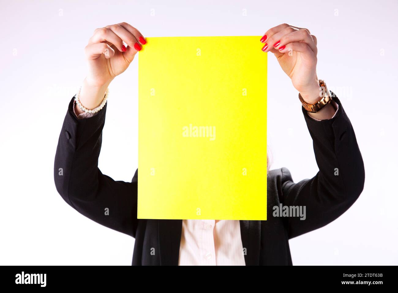Businesswoman hidding her face behind a yellow paper Stock Photo