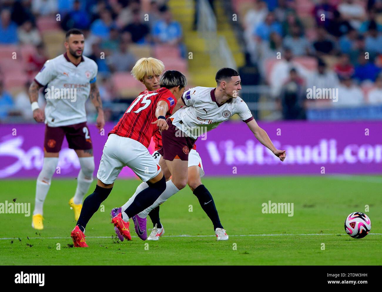 Manchester City's Phil Foden (right) battles for the ball with Urawa Red Diamonds' Yoshio Koizumi and Takahiro Akimoto during the FIFA World Cup Club Saudi Arabia 2023 semi-final match at the King Abdullah Sports City Stadium, Jeddah. Picture date: Tuesday December 19, 2023. Stock Photo