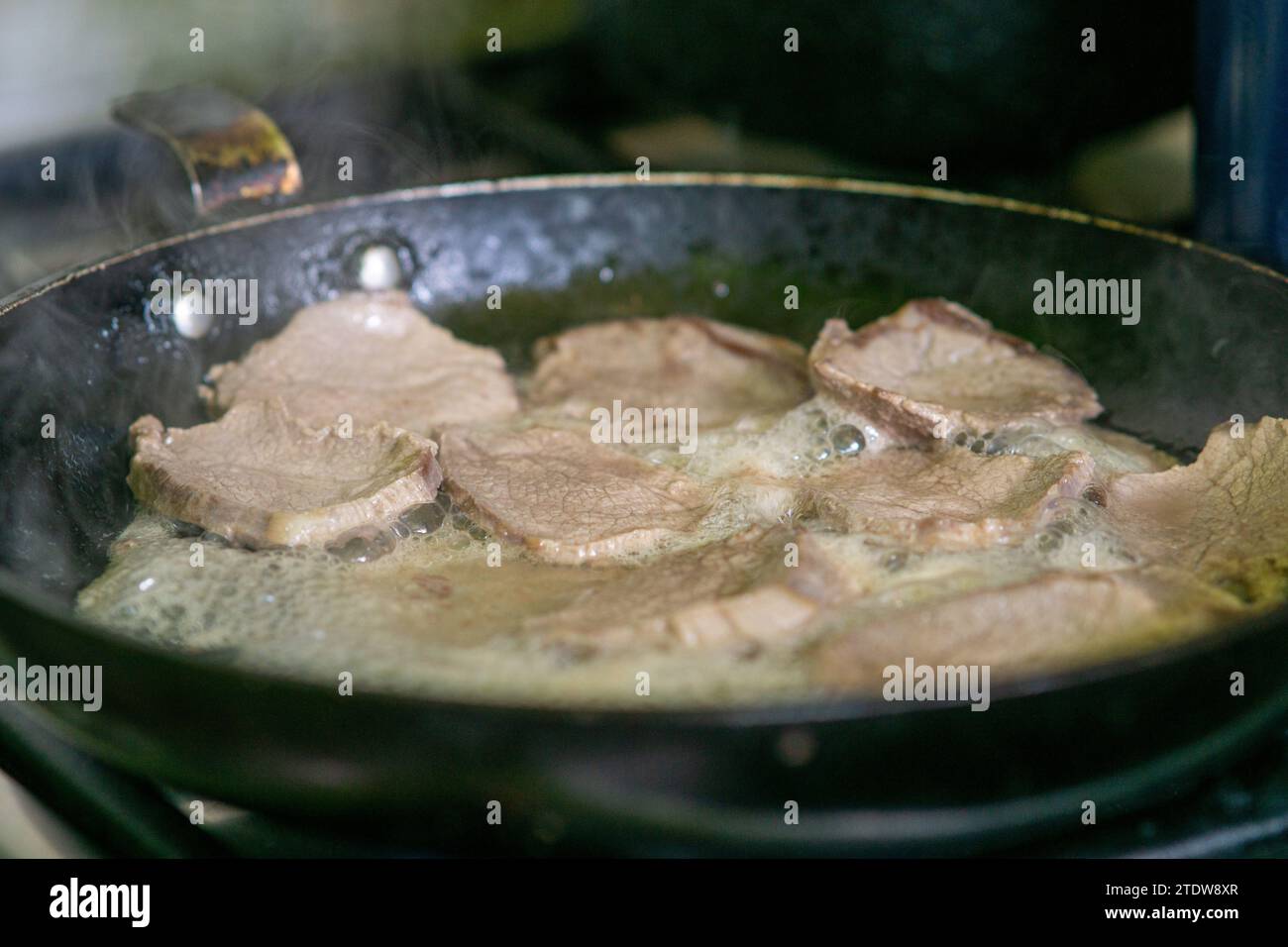 cooking loin steaks in a frying pan Stock Photo Alamy