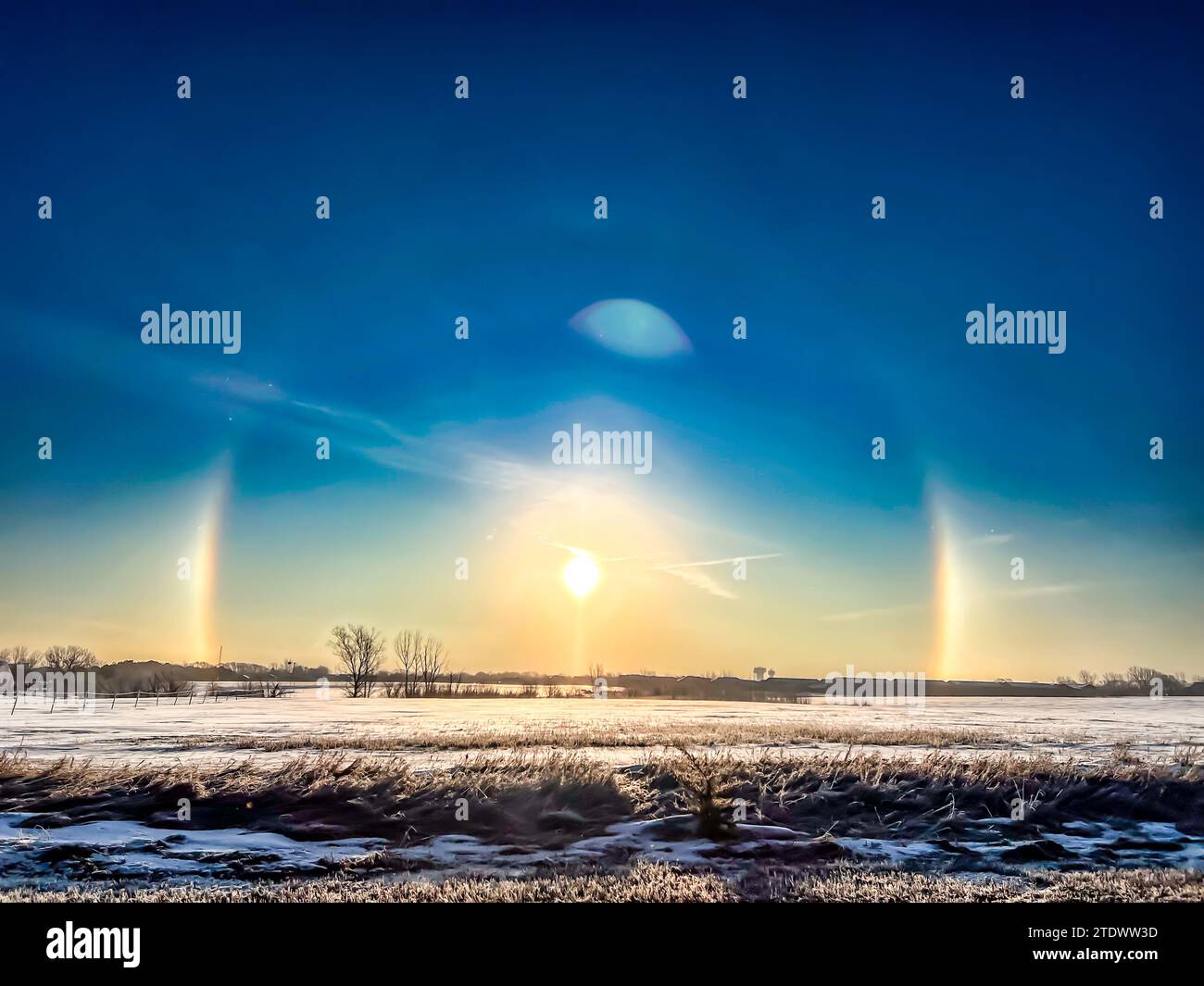 Atmospheric optical phenomenon sun dogs in the morning across a snow field.  Stock Photo