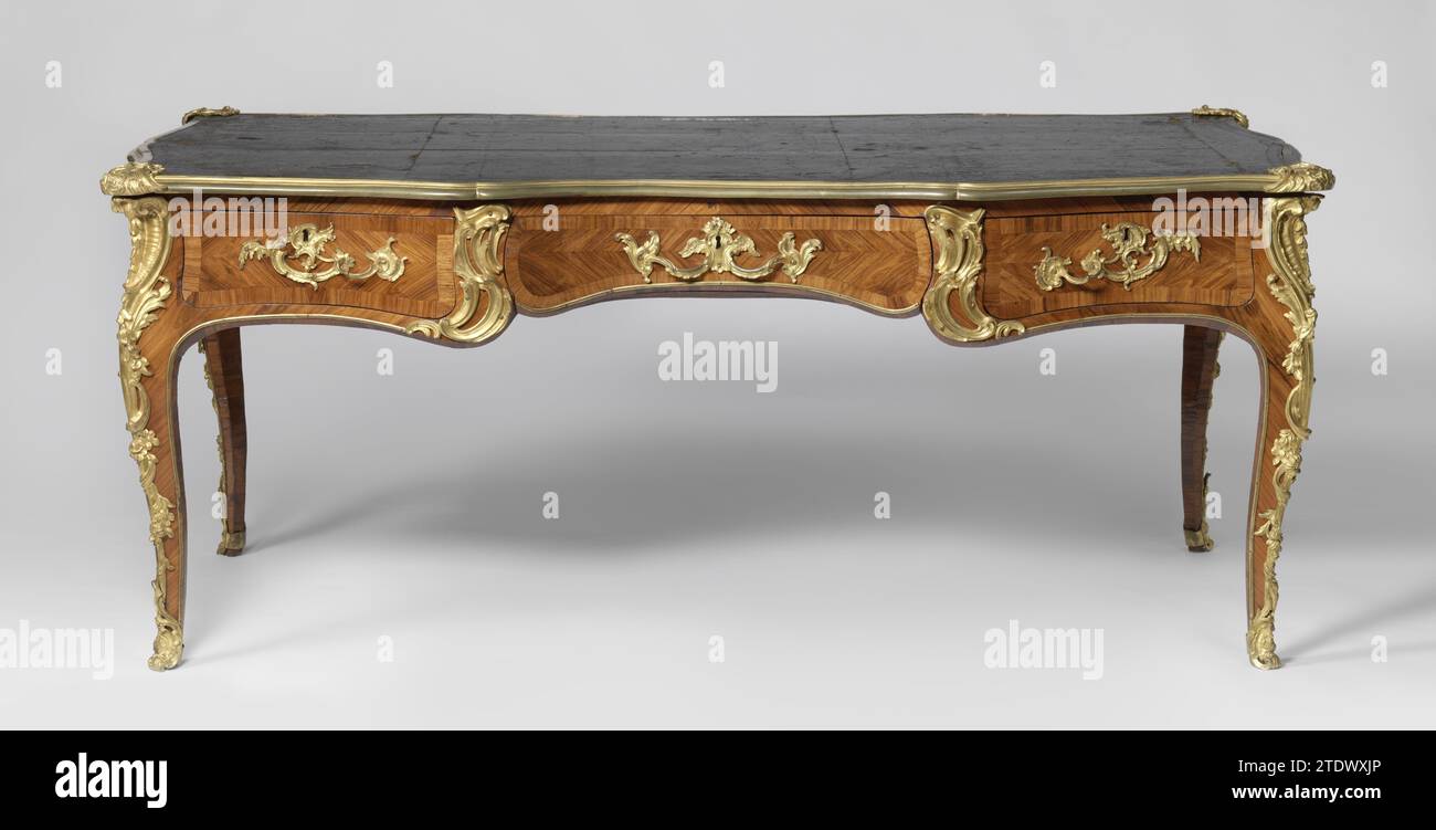 Writing table, Jacques Dubois (attributed to), c. 1745 Writing table decorated with marquetery of rose wood on oak core and gilded bronze. The S-shaped legs placed overhoek turn into the scalloped rules, on the front and back divided into three fields and decorated with herringbone motif. The tractors, the rules and legs bear fittings with rocaille motifs; Flower branches on the legs. A gilded bronze edge with corner pieces in rocaille motifs runs around the leaf, with black leather; Another border along the inside of the legs and bottom of the rules. Paris wood (plant material). oak (wood). s Stock Photo