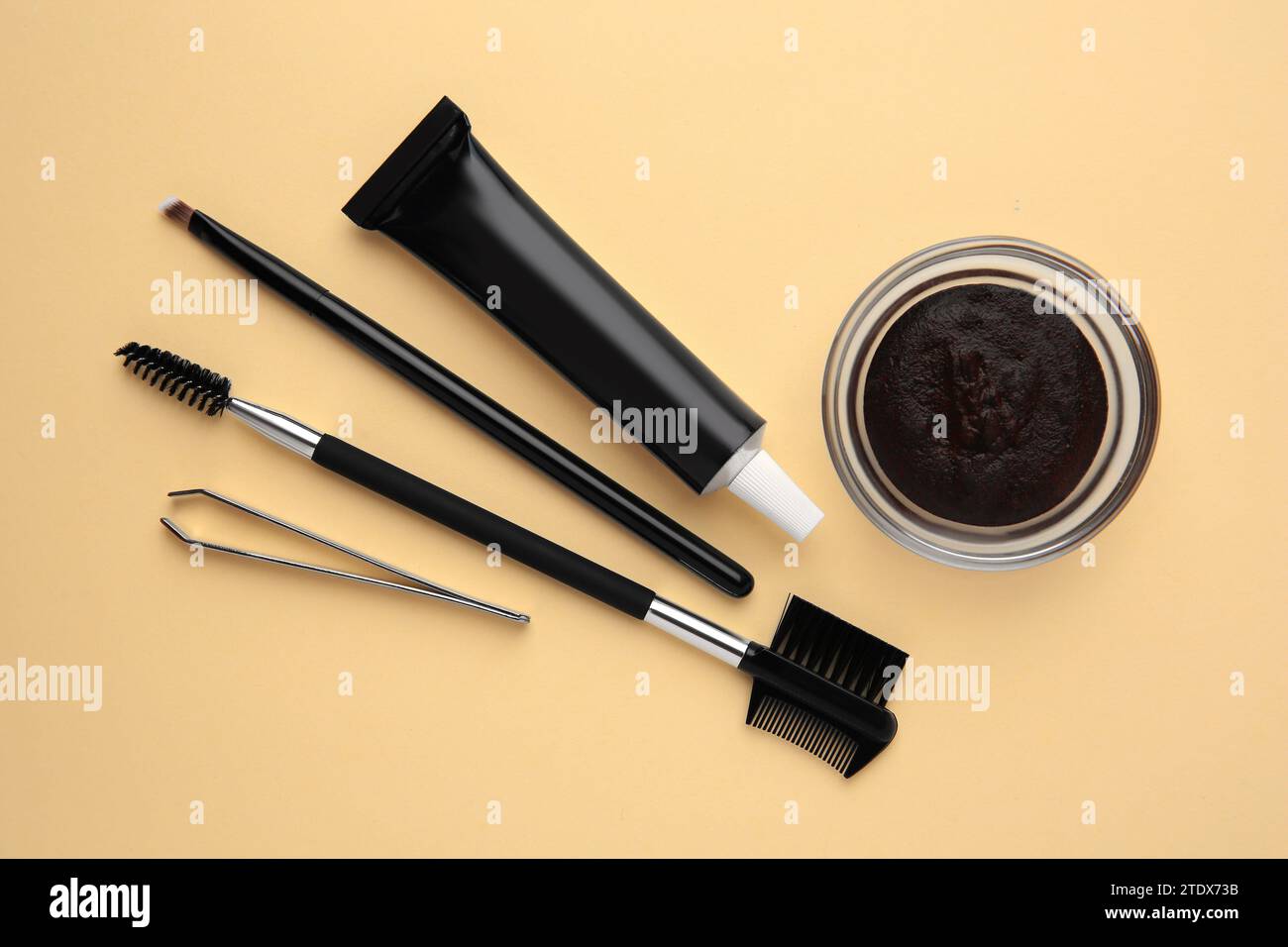 Flat lay composition with eyebrow henna and tools on beige background Stock Photo