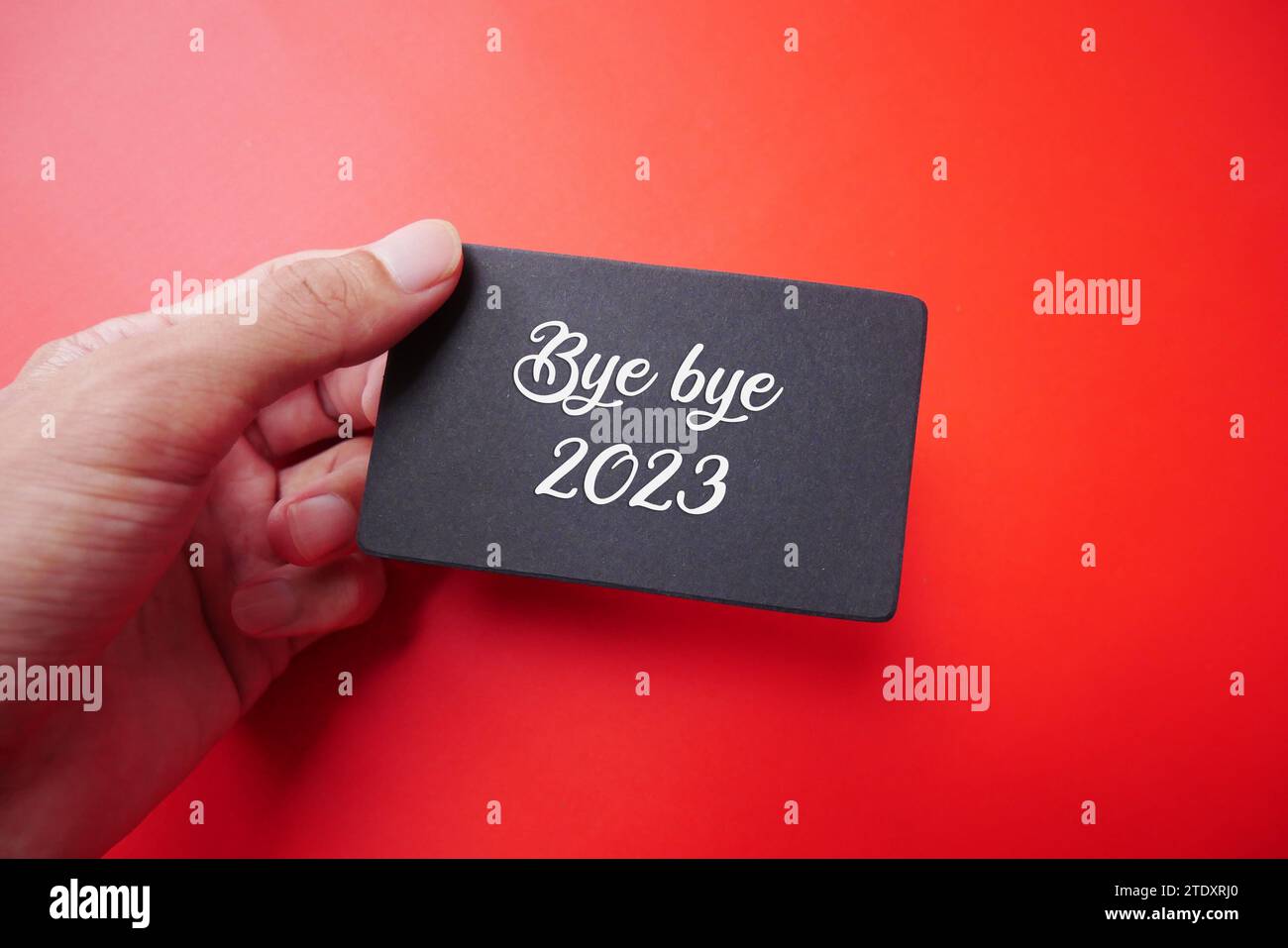Hand holding a piece of paper with the words Thank you 2023. BYE BYE