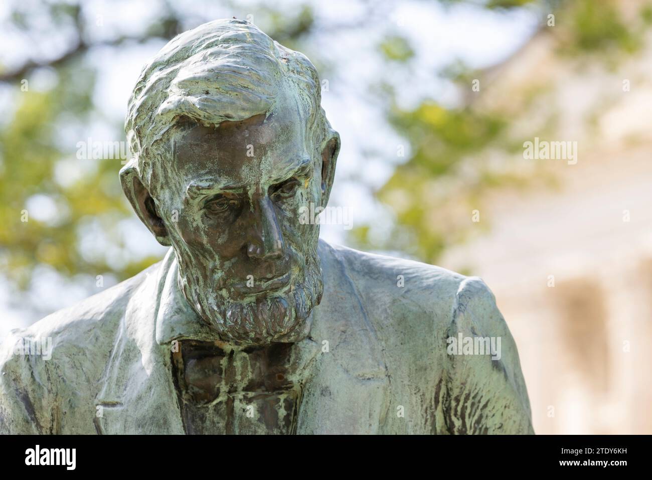 Topeka, Kansas, USA - June 17, 2023: Afternoon light shines on a public copper statue of Abraham Lincoln outside of the Kansas State capitol building. Stock Photo