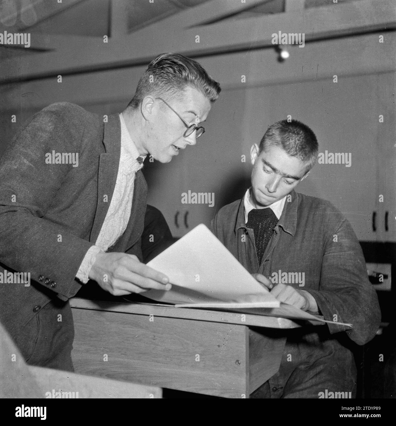 Boy in school desk with a teacher ca. October 1945 Stock Photo