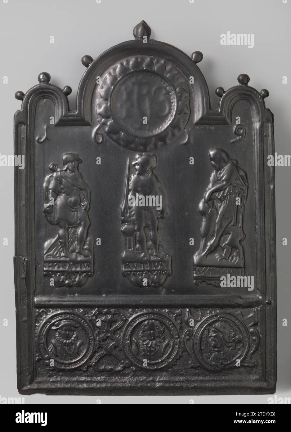 Haardplaat met Haracius, Meme en Samson, anonymous in or after c. 1619 Cast iron fireplace, consisting of two zones. In the upper zone there is a medallion with the letters IHS and immediately below the year 1619. Below three male figures standing on a console with their name, respectively Horace Cocles, Gaius Mucius Scaevola and Samson. In the lower zone three medallions with bustes separated from each other by rankwork. The two left medallions show a bust and face, with a man on the left and a woman on the right. The right medallion shows the bust of a man and profil. All figures and medalli Stock Photo