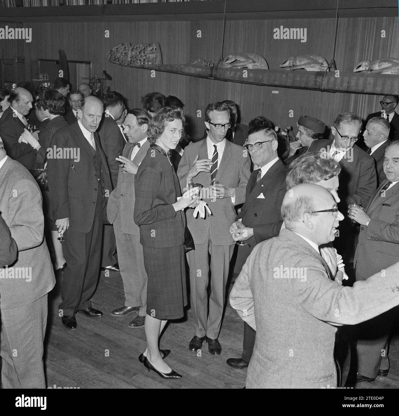 Men and women at a cocktail party talking and drinking and having a good time ca. April 10, 1964 Stock Photo