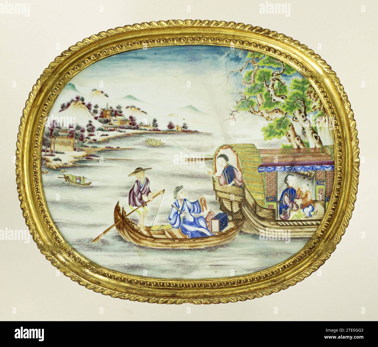 Oval panel with figures in boats in a riverlandscape, anonymous, c. 1770 - c. 1775 Porcelain oval plaque, painted on the glaze in blue, red, pink, green, yellow, purple, brown, black and gold. The show shows a river landscape with mountains, trees, pavilions and boats. In the foreground a small boat with a rower and a man with objects. They sail next to a larger boat, where a woman leans from the rear. The man shows her an object. In the larger boat a second woman and a boy. Original gilded list. Porcelain with email colors. China Porcelain. Glaze. Gold (Metal). List: Wood (Plant Material) pai Stock Photo