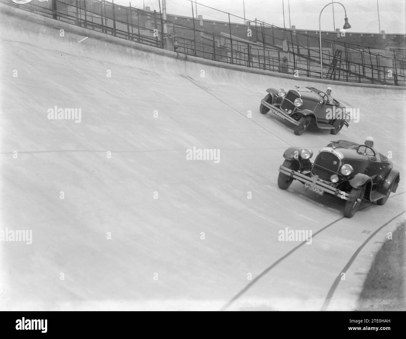 Two Chrysler Convertible sports cars driving counterclockwise on the