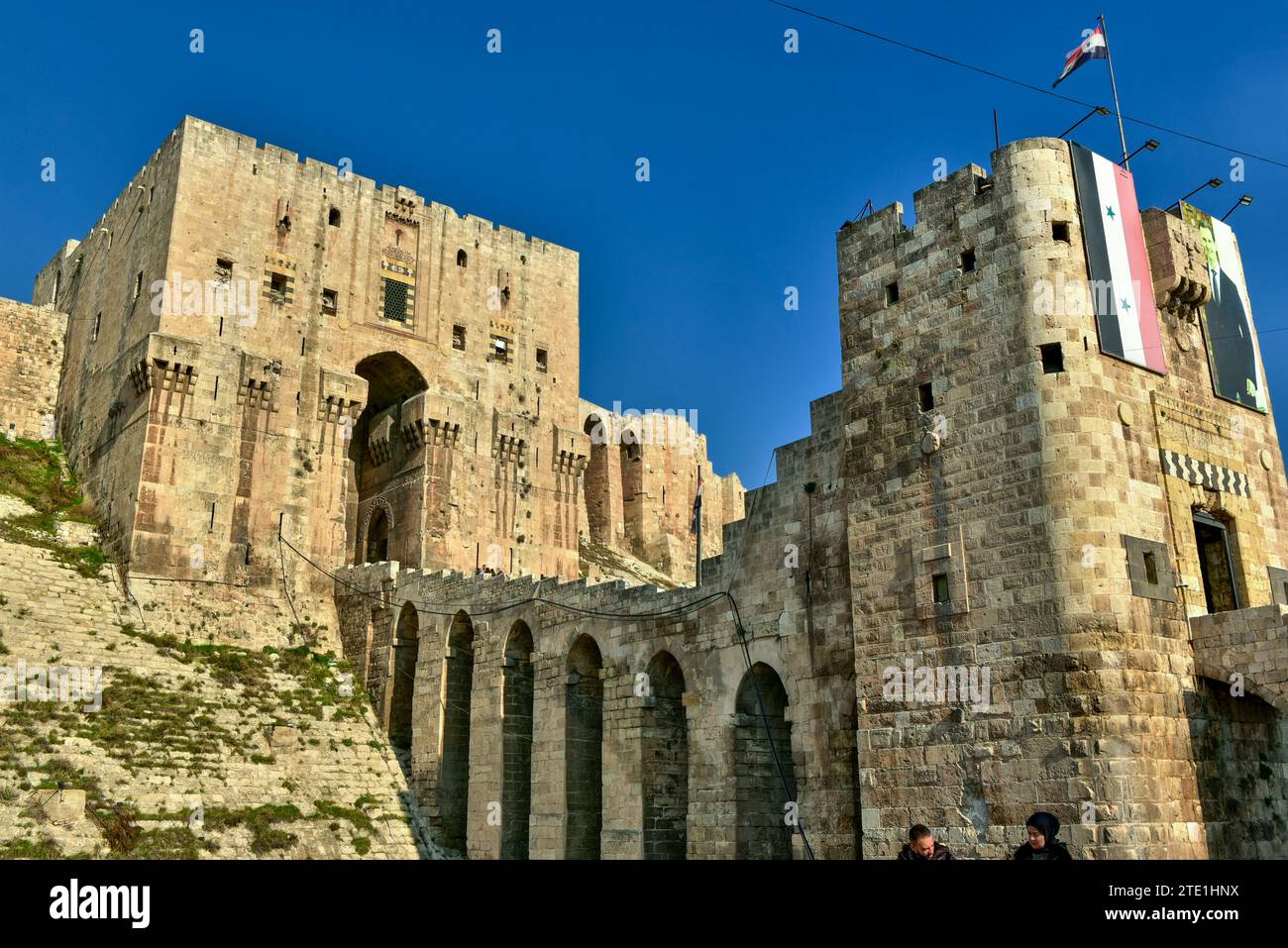 Syrian Flag and photo of Bashar al-Assad on the front gate of the Citadel of Aleppo, one of the oldest and largest castles in the world Stock Photo