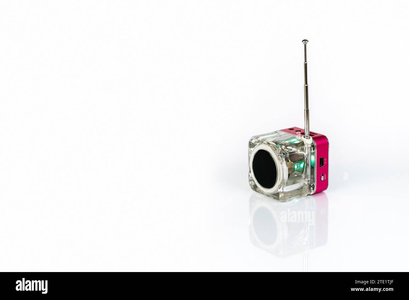 A small cube-shaped radio receiver on a white background with reflection Stock Photo
