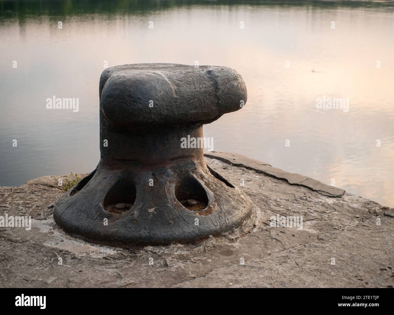 Mooring bollard on the background of the river in soft focus at sunset Stock Photo