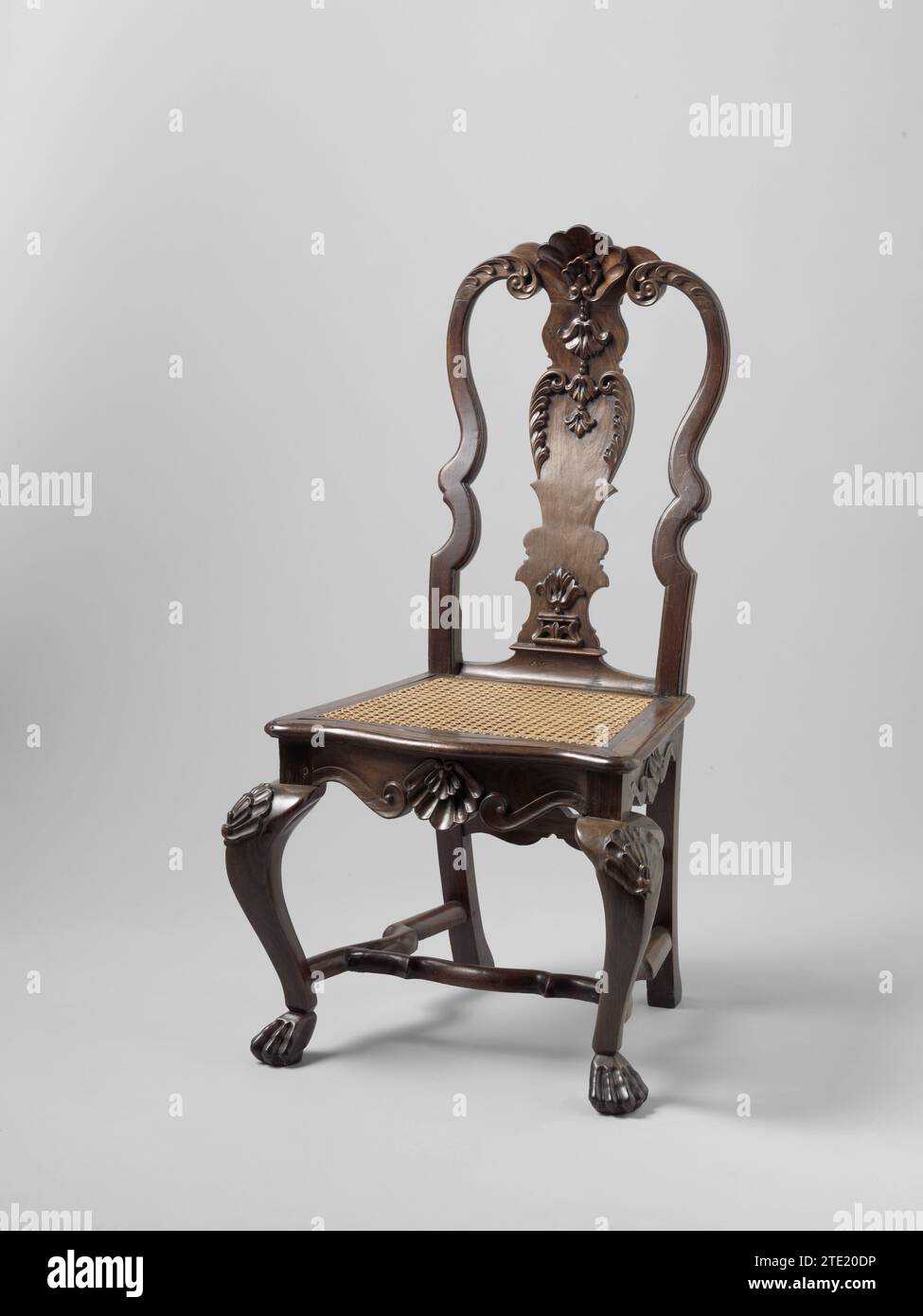 Iron wood chair and rattan -stretched seat (series of 4 seats), Anonymous, 1725 - 1750 Chair (series of four identical seats BK-1994-A, B, C, D) of ironwood with rattan-stretched seat. Faint backwards bent hind legs and overhoeks placed S-shaped front legs that end in Leeuklauws and are decorated at the top with shell motifs. The cross has scalloped side sports and a scalloped cross -sport. The hind legs are connected by a second transverse sport under the session. The lower edge of the seating rules on front and sides is made up of two S-Voluten with a shell motif in the middle. The high back Stock Photo