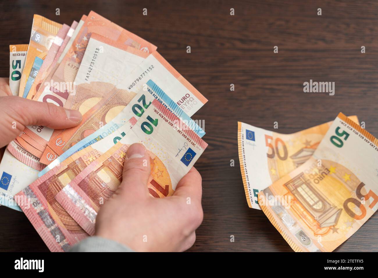 Hamburg, Germany - December 2, 2023: Man counts a large amount of cash euro bills *** Mann zählt eine große Menge Bargeld Euro Scheine Stock Photo