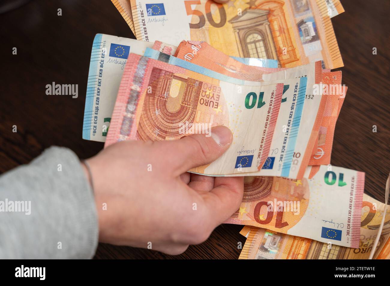 Hamburg, Germany - December 2, 2023: Man counts a large amount of cash euro bills *** Mann zählt eine große Menge Bargeld Euro Scheine Stock Photo