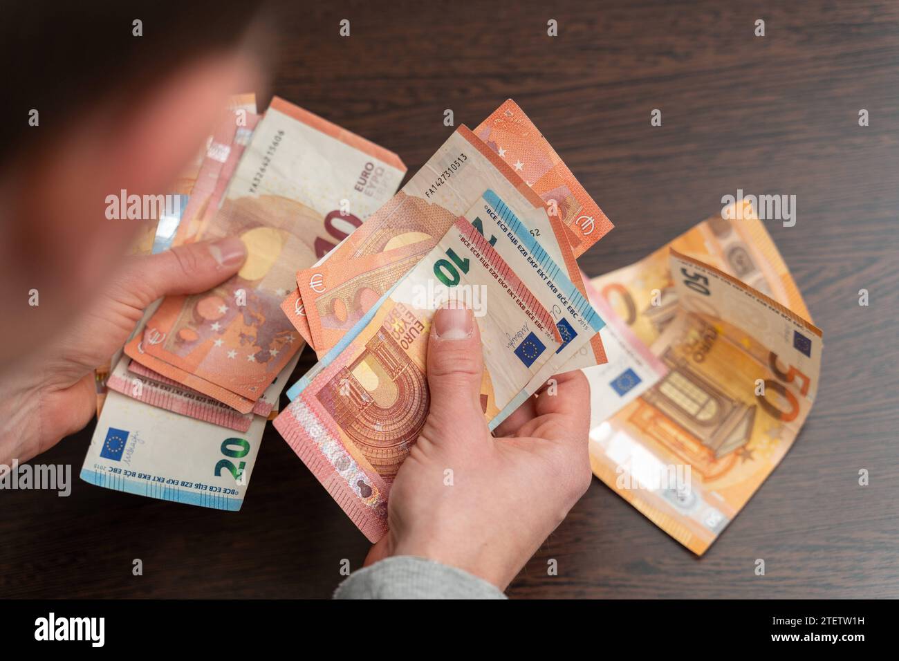 Hamburg, Germany - December 2, 2023: Man counts a large amount of cash euro bills *** Mann zählt eine große Menge Bargeld Euro Scheine Stock Photo