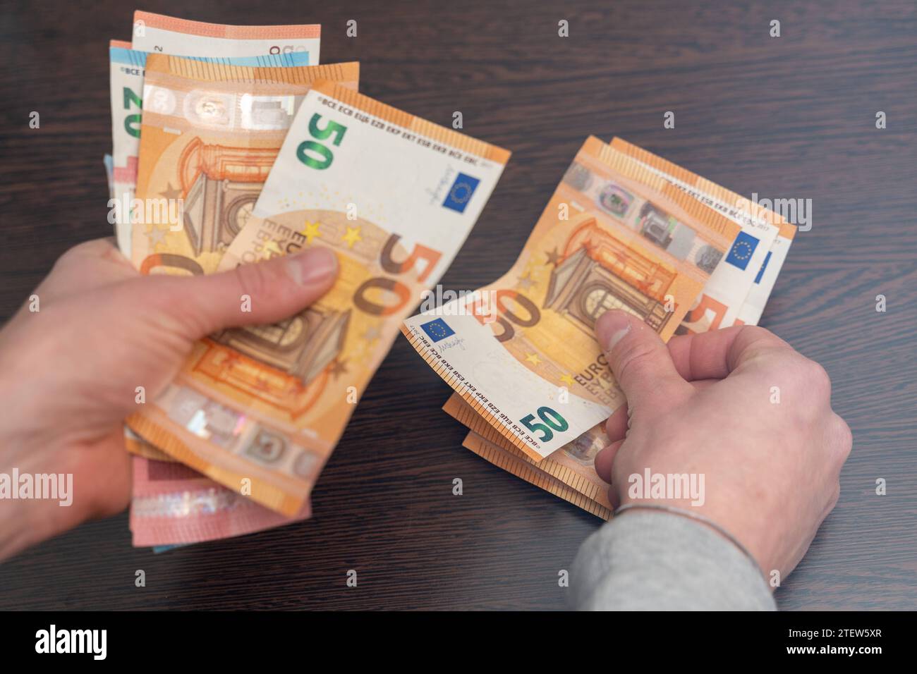 Hamburg, Germany - December 2, 2023: Man counts a large amount of cash euro bills *** Mann zählt eine große Menge Bargeld Euro Scheine Stock Photo