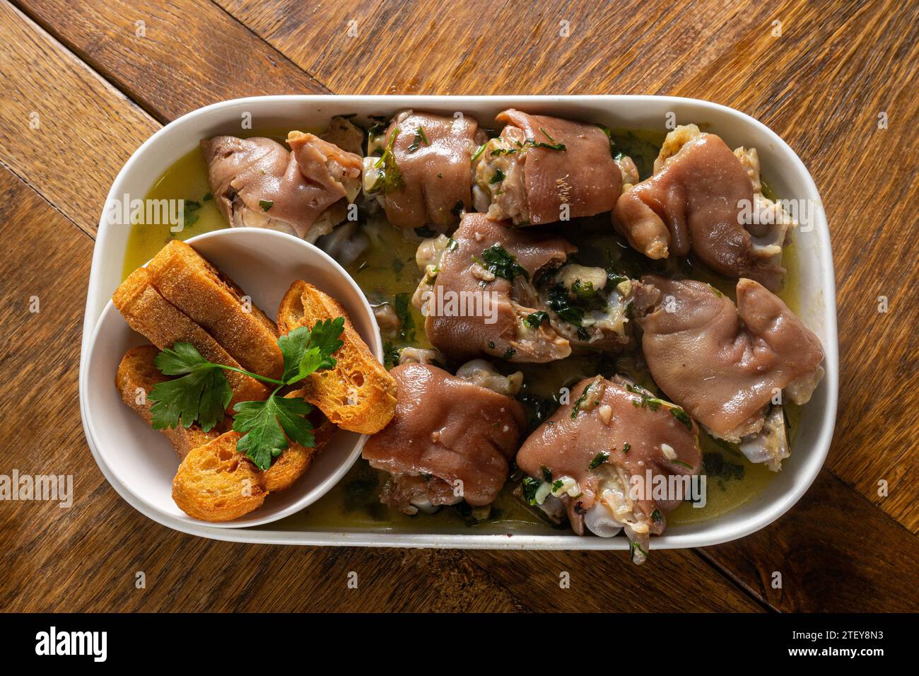 Authentic Portuguese Alentejo Pig Trotters with Coriander Sauce, a traditional delicacy capturing the essence of Portuguese cuisine. Stock Photo