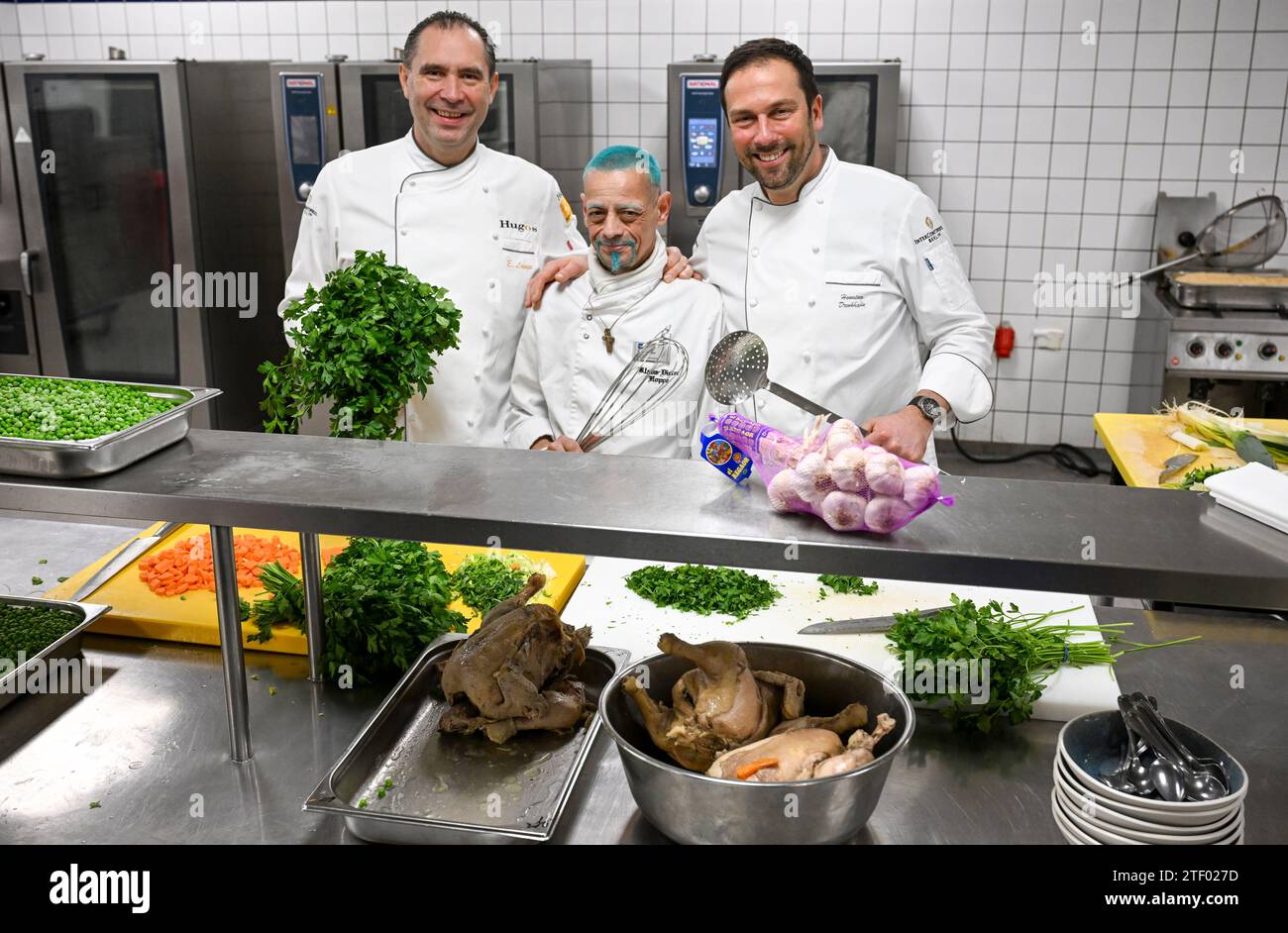 Berlin, Germany. 20th Dec, 2023. Michelin-starred chef Eberhard Lange (l-r), City Mission chef Klaus Hoppe and InterContinental head chef Henning Drenkhahn cook for homeless people at the Intercontinental Hotel Berlin at Christmas. The food will be served on a total of eight evenings between Christmas and New Year at the Berlin City Mission's emergency shelters. Credit: Jens Kalaene/dpa/Alamy Live News Stock Photo