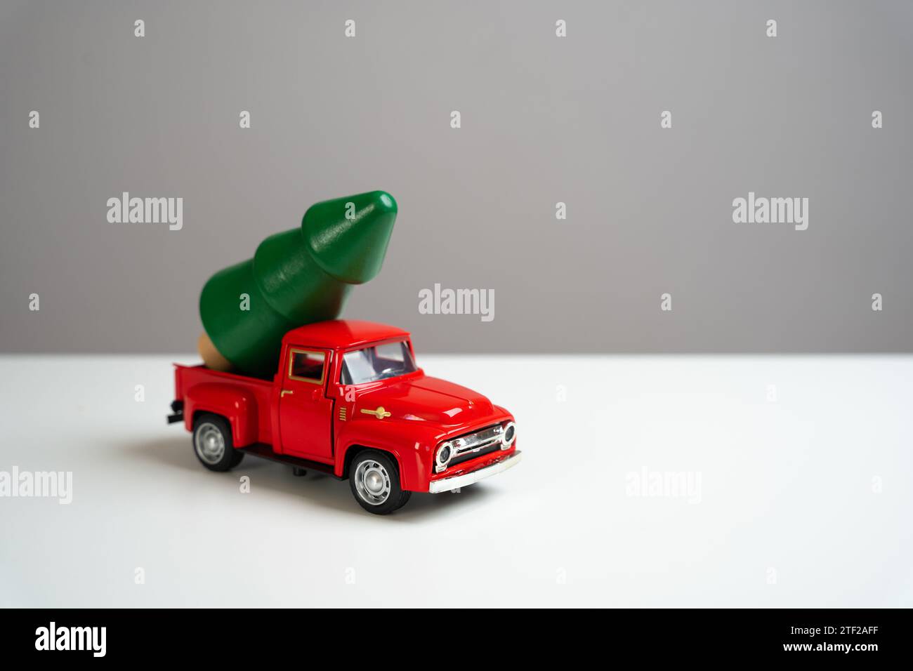 A old-fashioned red pickup truck with a Christmas tree in the back ...