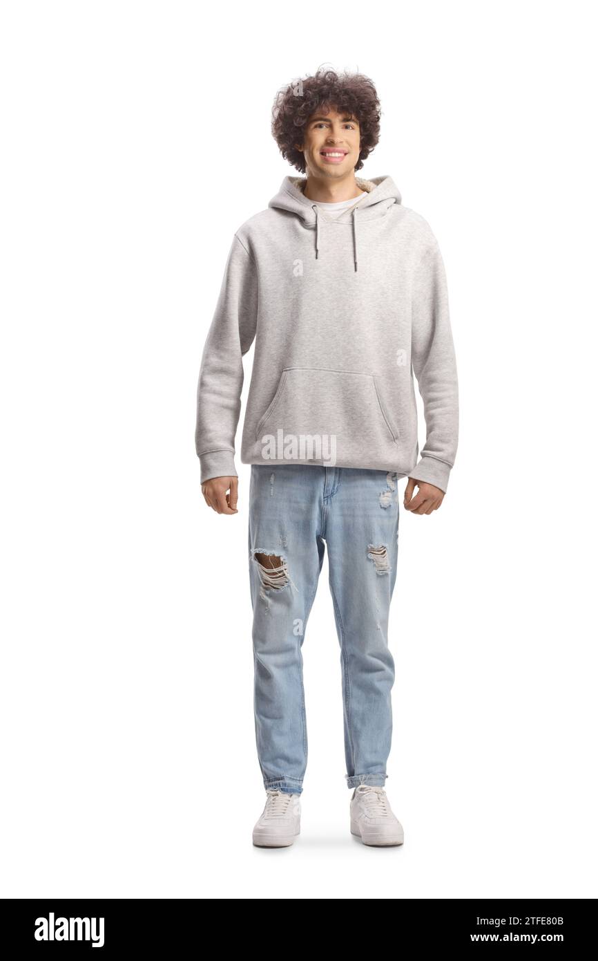Full length portrait of a guy with curly hair in a gray hoodie and jeans isolated on white background Stock Photo
