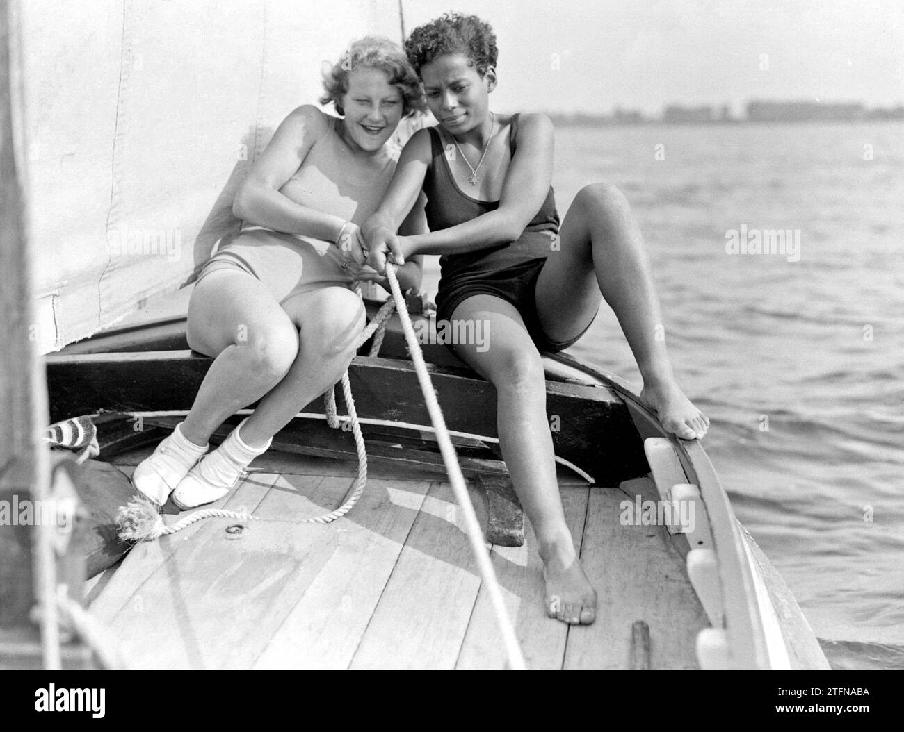Model Eva Waldschmidt (l) and an unknown woman pulling a rope in a sailboat ca. 1932 Stock Photo
