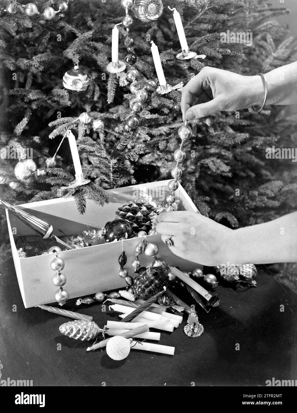 Woman takes Christmas decorations out of a box to decorate a Christmas