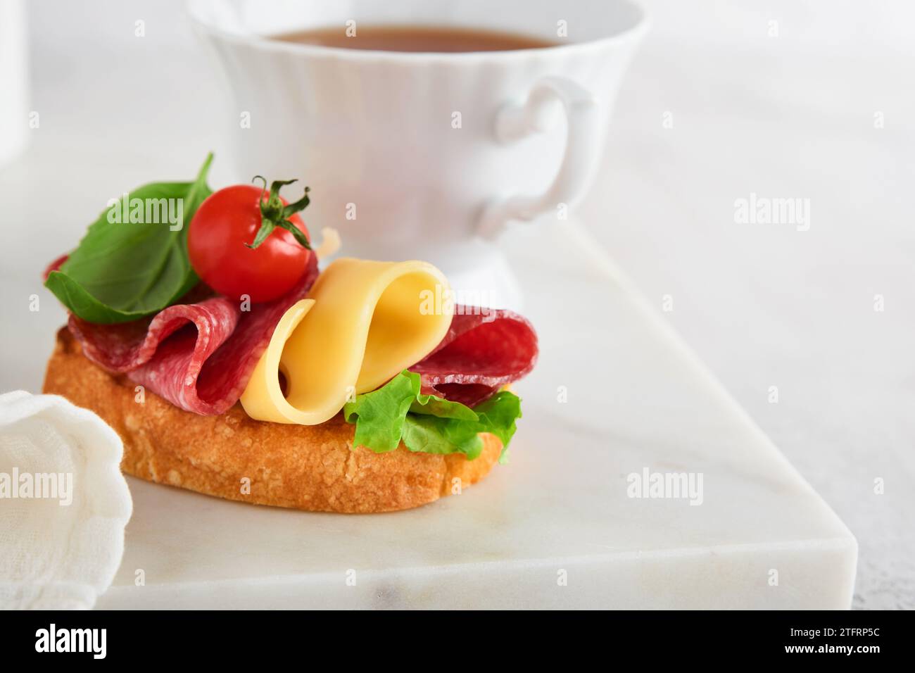 Salami sandwich. Delicious toasted sandwiches with slice salami, cheddar cheese lettuce and tomatoes cherry on white marble background. Restaurant men Stock Photo