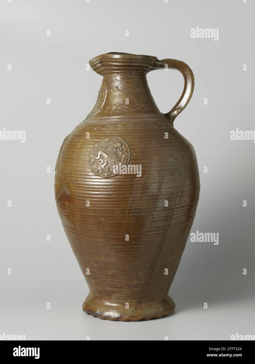 Storrage vessel with a coat of arms and lions, anonymous, 1604 Stock jug of stoneware on wavy base with an egg -shaped body and wide neck with a pinched spout. The C-shaped ear is attached to the neck and shoulder. Profiles on the neck and shoulder. Covered with a brown Engobe. The jug is decorated with turning rings. On the neck in relief a printed and imposed medallion with a weapon and the edge 'I.wilhelmvs.vo.reifenberg m.i.anna vom Batemborg.1604'. The belly with three smaller medallions with a lion, the brand 'W.E.' and the date '1600'. On the neck and shoulder tires with entry, wavy lin Stock Photo