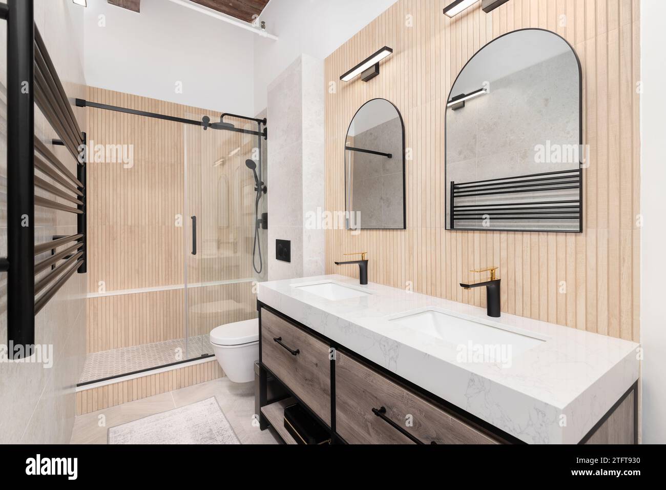 A bathroom with a wood slat accent wall, a marble slab countertop on a