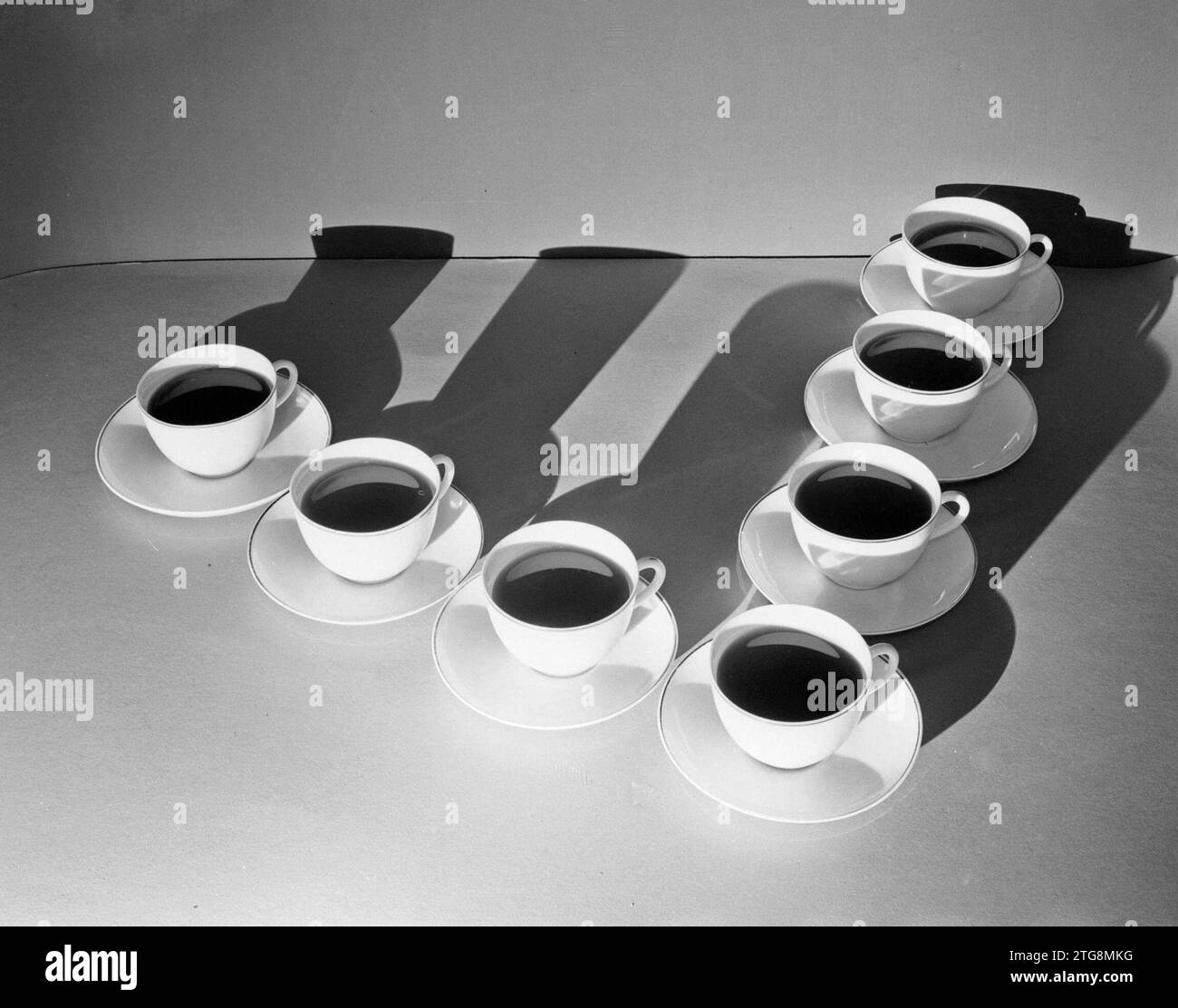 Cups and saucers filled with drinks (probably coffee), arranged in a v
