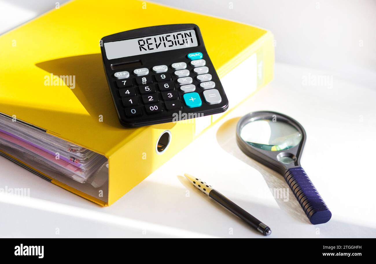 Calculator with the word REVISION. Business concept for the act of reviewing someone, such as auditing or accounting. Stock Photo