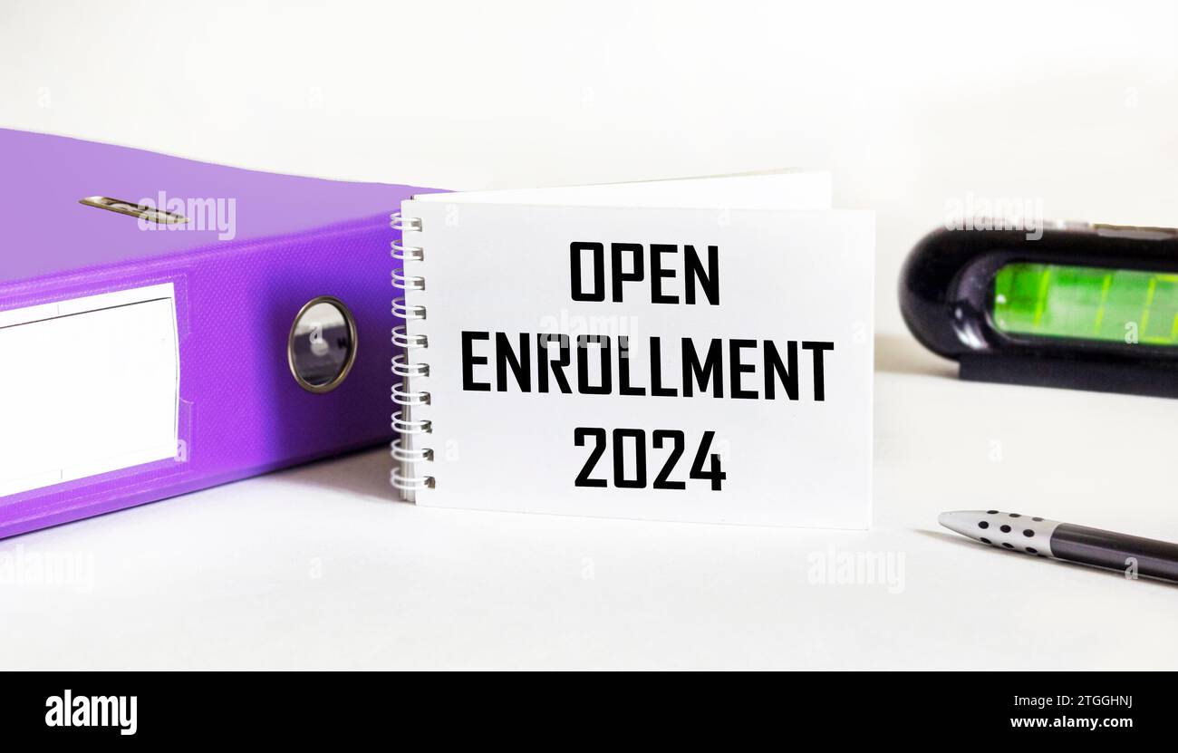 Open enrollment 2024 is open. text on a notepad next to a clock and a