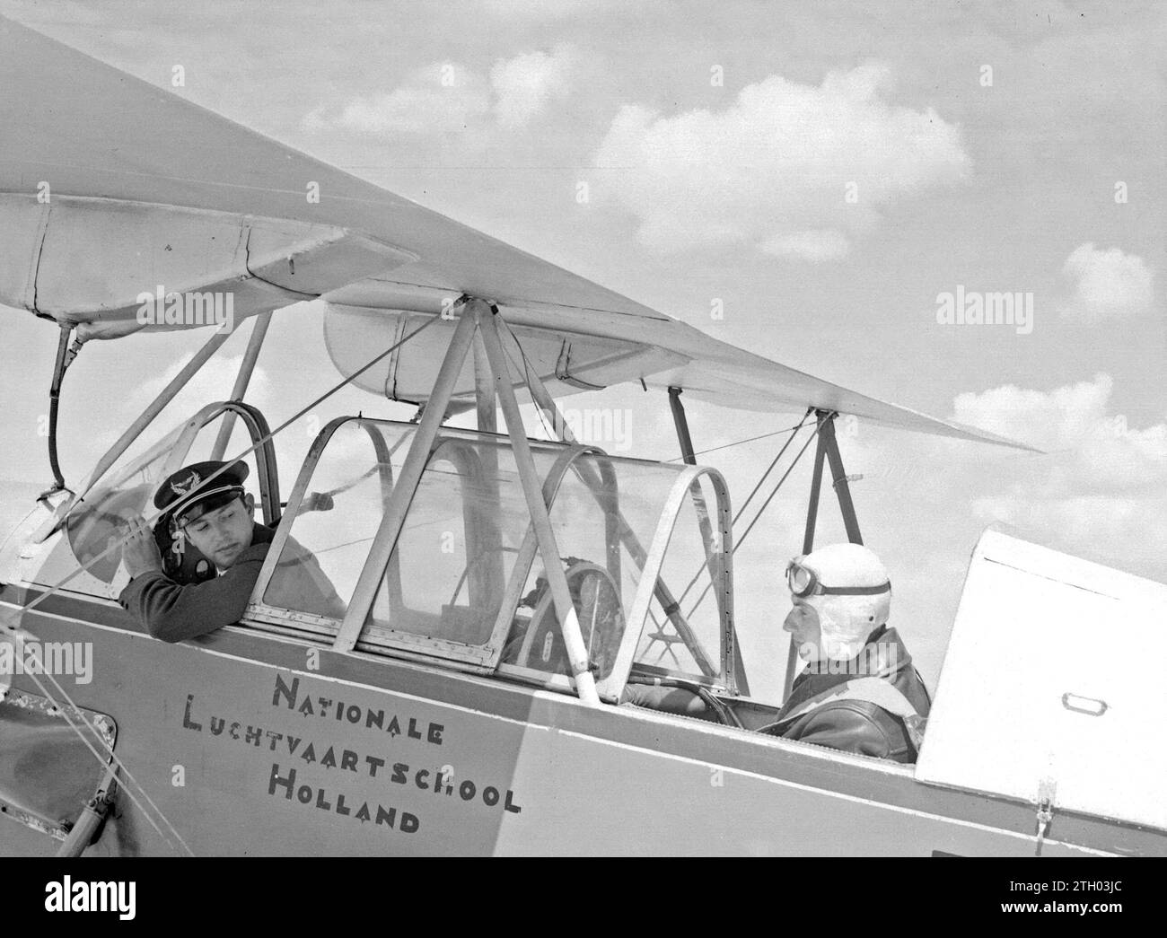 A Koolhoven FK-46 training aircraft nicknamed 'Koe or Koebeest' because of its docile flying behavior from the National Aviation School Holland at Amsterdam Schiphol with instructor and student. ca. 1933 Stock Photo