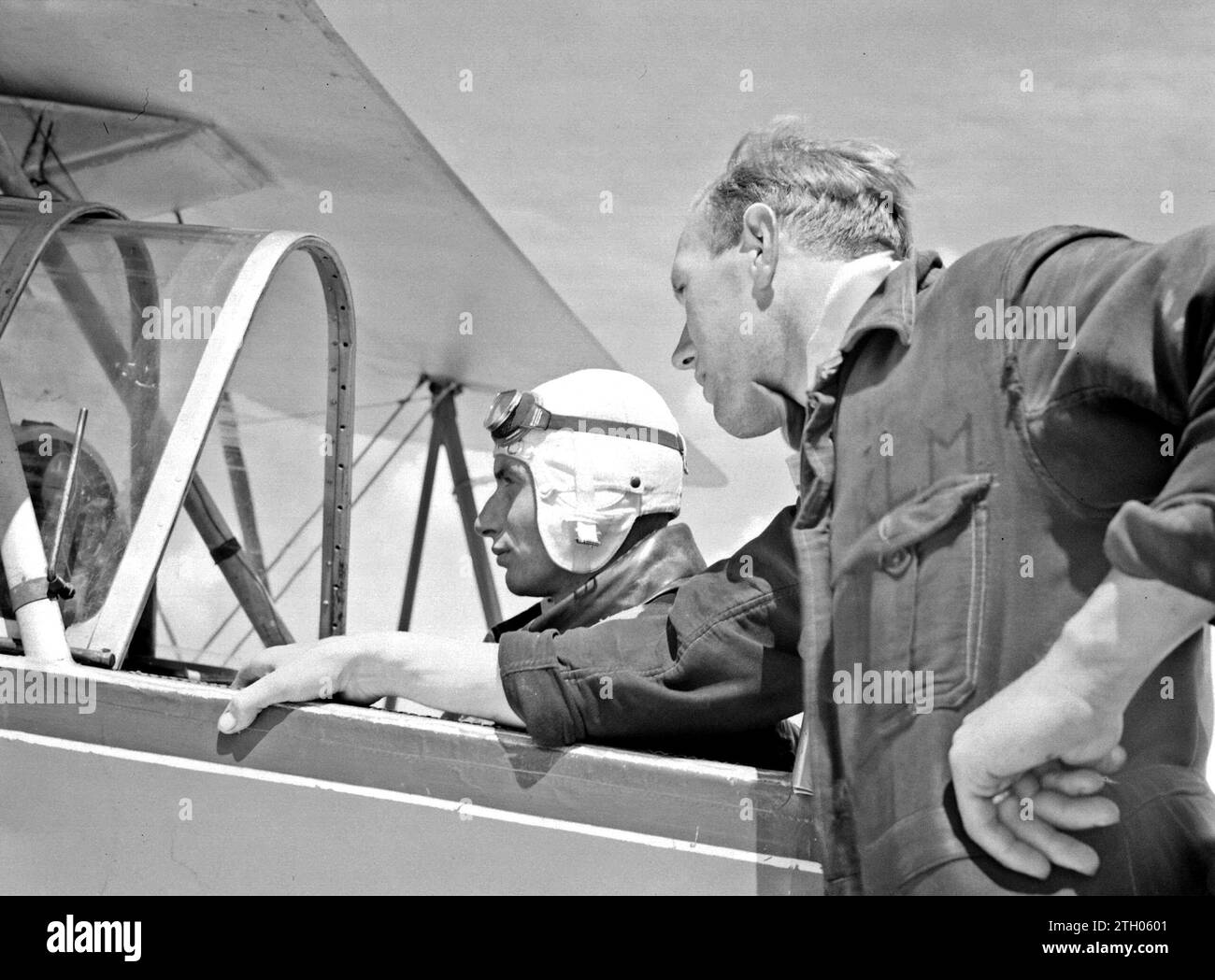 A mechanic leaning against and an aspiring pilot sitting in a Koolhoven FK-46, nicknamed 'Koe or Koebeest' by the National Aviation School at Amsterdam Schiphol because of its docile flying behaviour. ca. 1933 Stock Photo
