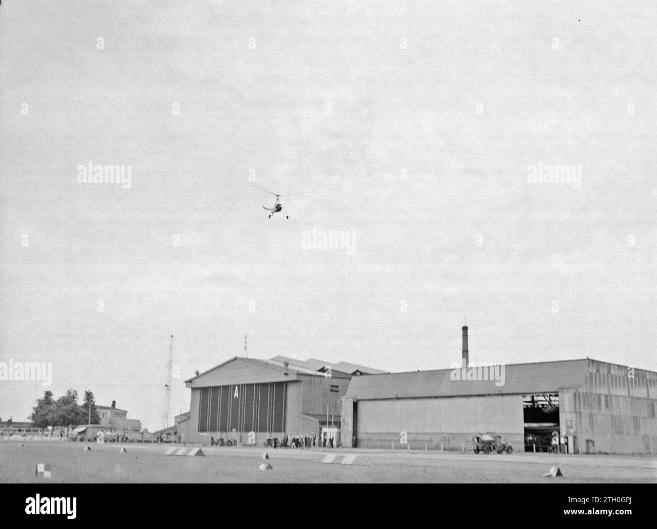 The Cierva autogyro PH-HHH named 'Donna Dulcinea' of the Netherlands Aviation School flying above the hangars of Rotterdam Waalhaven Airport ca. 1935 Stock Photo