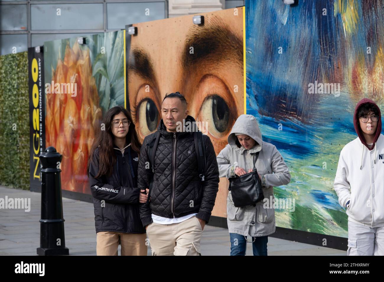 As the National Gallery celebrates its 200th year a hoarding featuring details from many well known paintings by famous artists, including Portrait of a Man by Antonello da Messina as seen here, interact with passers by on 16th October 2023 in London, United Kingdom. Stock Photo