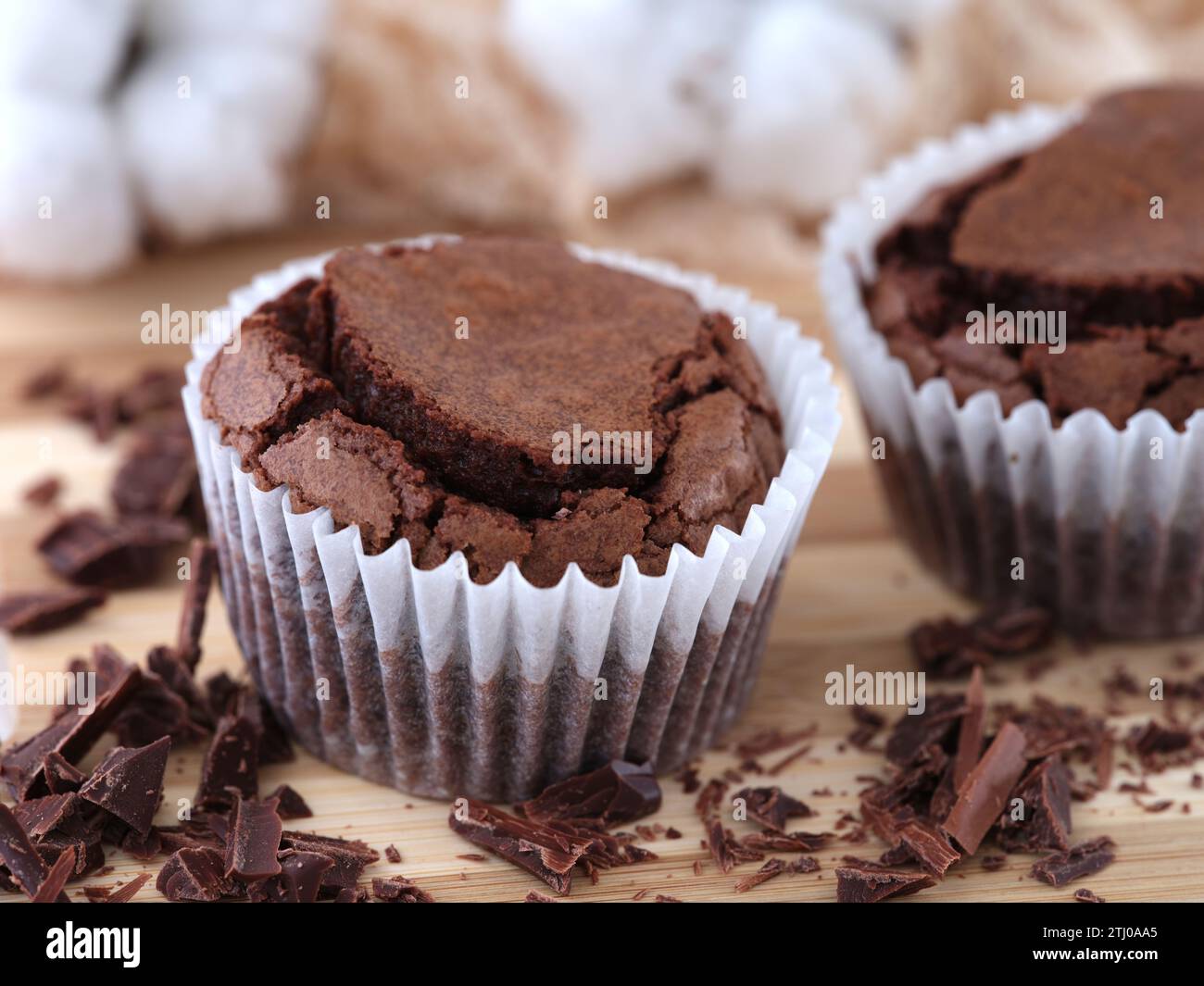 Gluten free chocolate brownies lying on a wooden surface with chocolate near them. Stock Photo