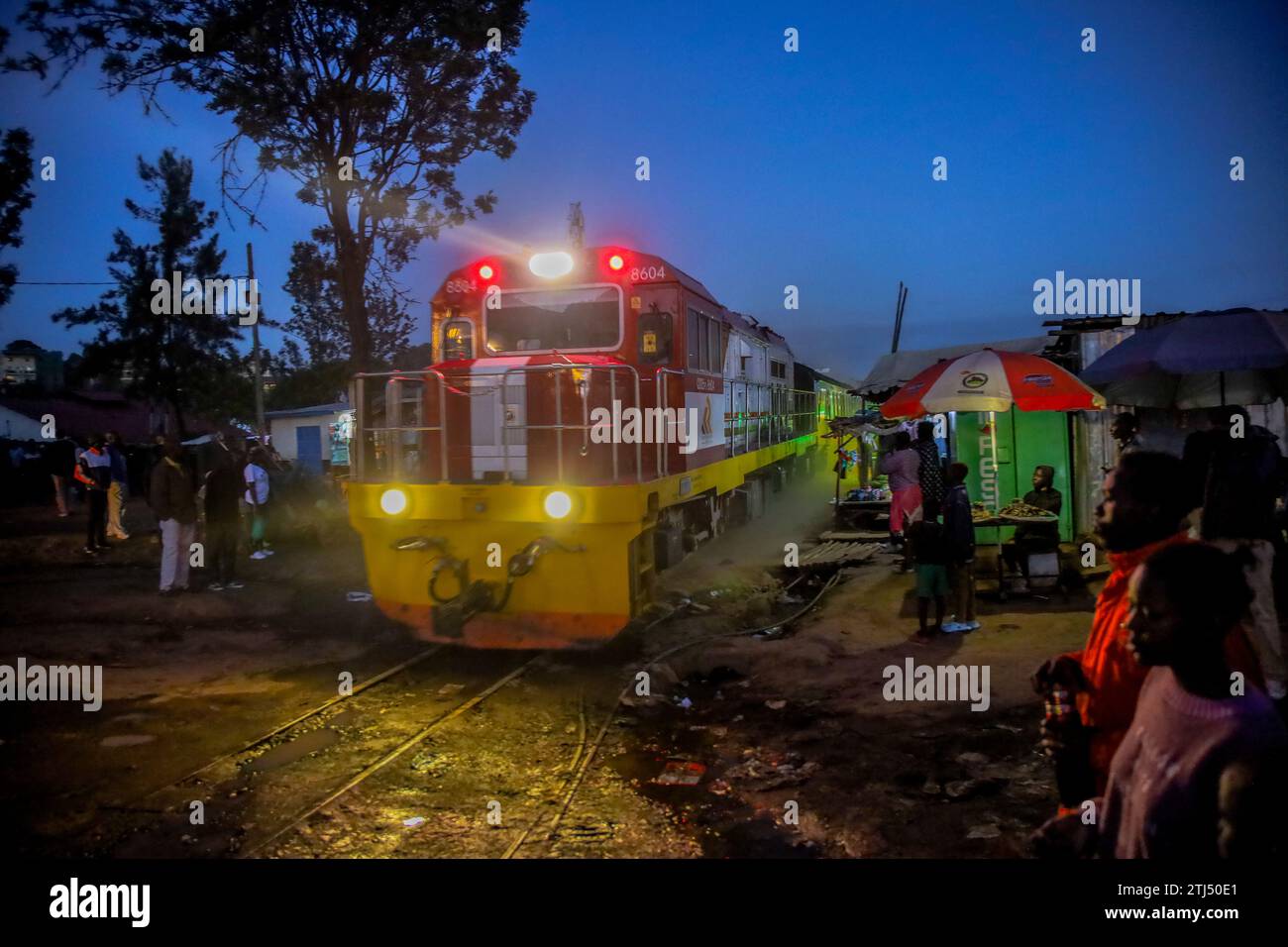 The late evening Nairobi to Kisumu passenger train drives past Kibera