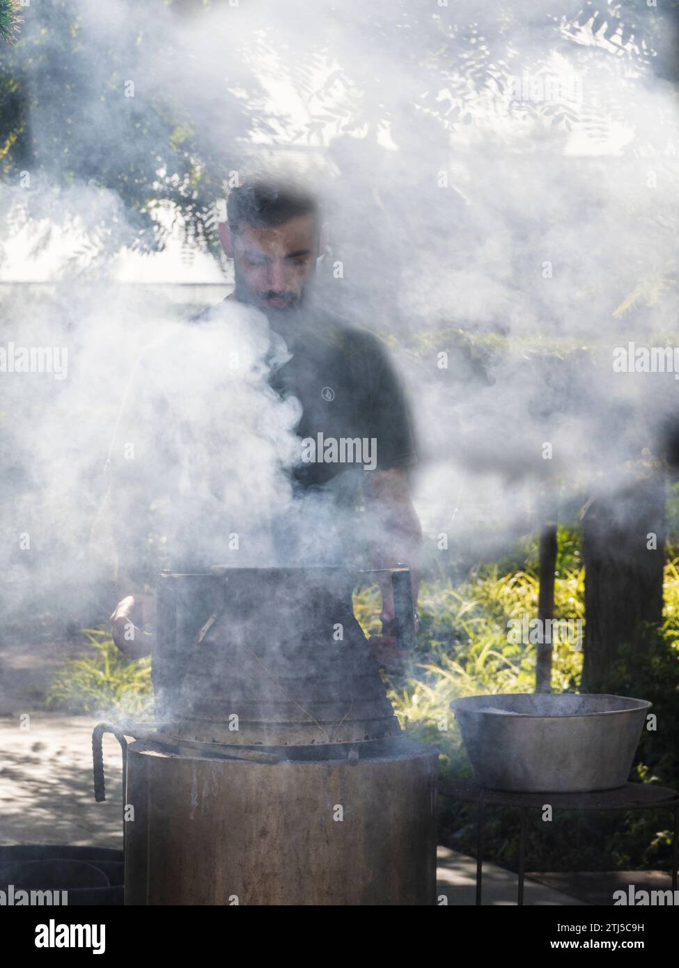 Man roasting chestnuts along the Avenida do Mar in Funchal, Madeira. Stock Photo